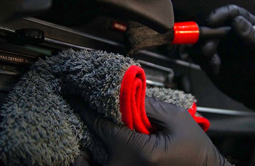 Innenraumpflege und Veredelung mit Pinsel eines Amaturenbretes im Auto